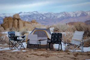 Camp chairs by a tent in a mountain campsite