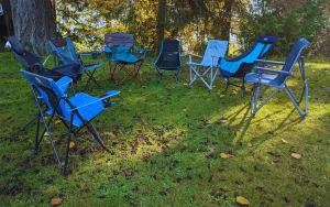 Different camp chairs set up near a tent for price comparison