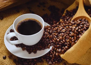 Lifeboost Coffee cup with roasted beans on burlap surface