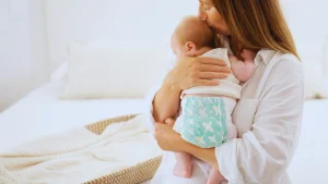 Mother holding baby wearing Rascal and Friends Diaper