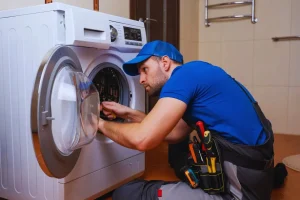 Technician repairing front load washers with agitators.