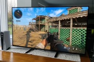 Gamer playing FPS on large screen TV