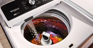 Top load washers with agitators washing colorful clothes.