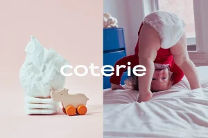 Coterie Diaper worn by baby and stacked on bed
