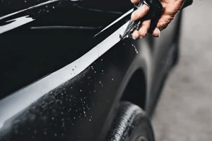 Applying paint protection film on a shiny black car
