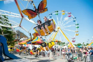 People enjoying a colorful themed swing ride at Expo St Hyacinthe