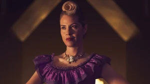 Leslie Grossman in a purple dress with styled hair