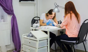 Nail technician performing manicure for client at salon