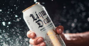 Hand grips a cold Liquid Death Mountain Water